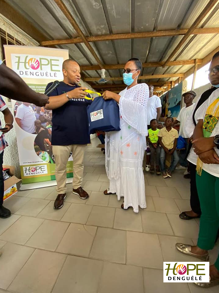 Le président de Hope Denguélé Ousmane TOURE offrant un lot de kits scolaires à la fondatrice de l'orphelinat